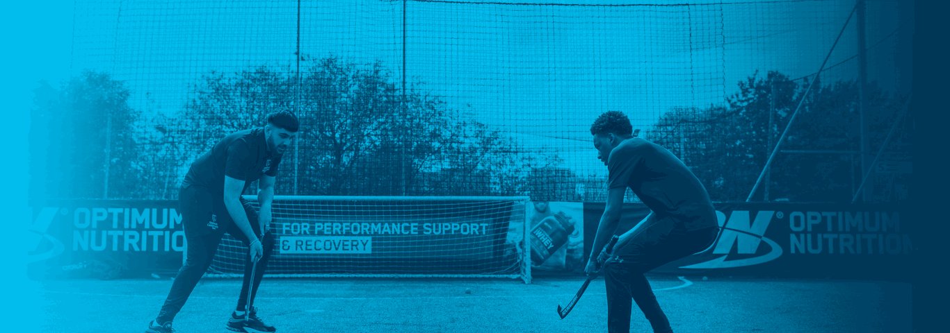 two students playing hockey, blue overlay