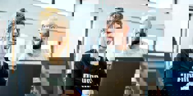 two students at a desk on their chromebooks