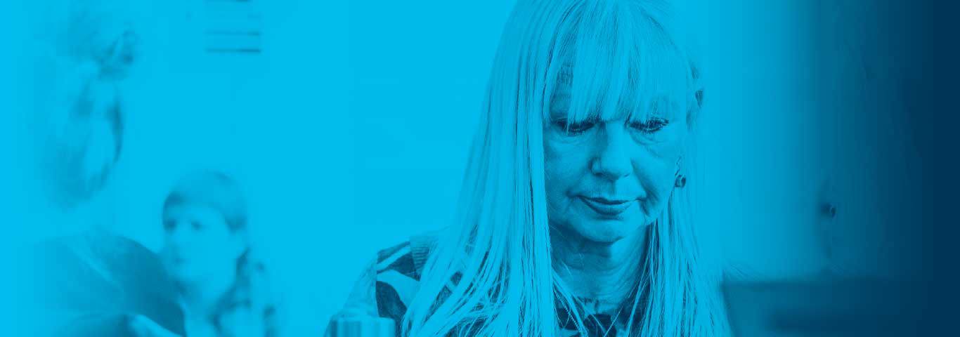 student looking down smiling, blue overlay