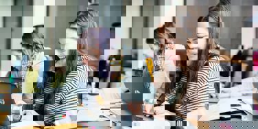 Students smile at chromebooks while working