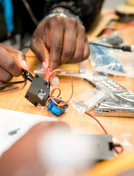 hands touching a servo motor with crocodile clips