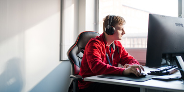 student sat at a computer with headset on