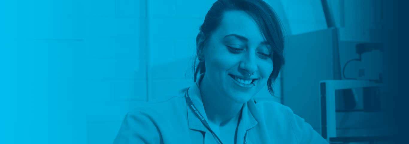 science student looking down smiling, blue overlay